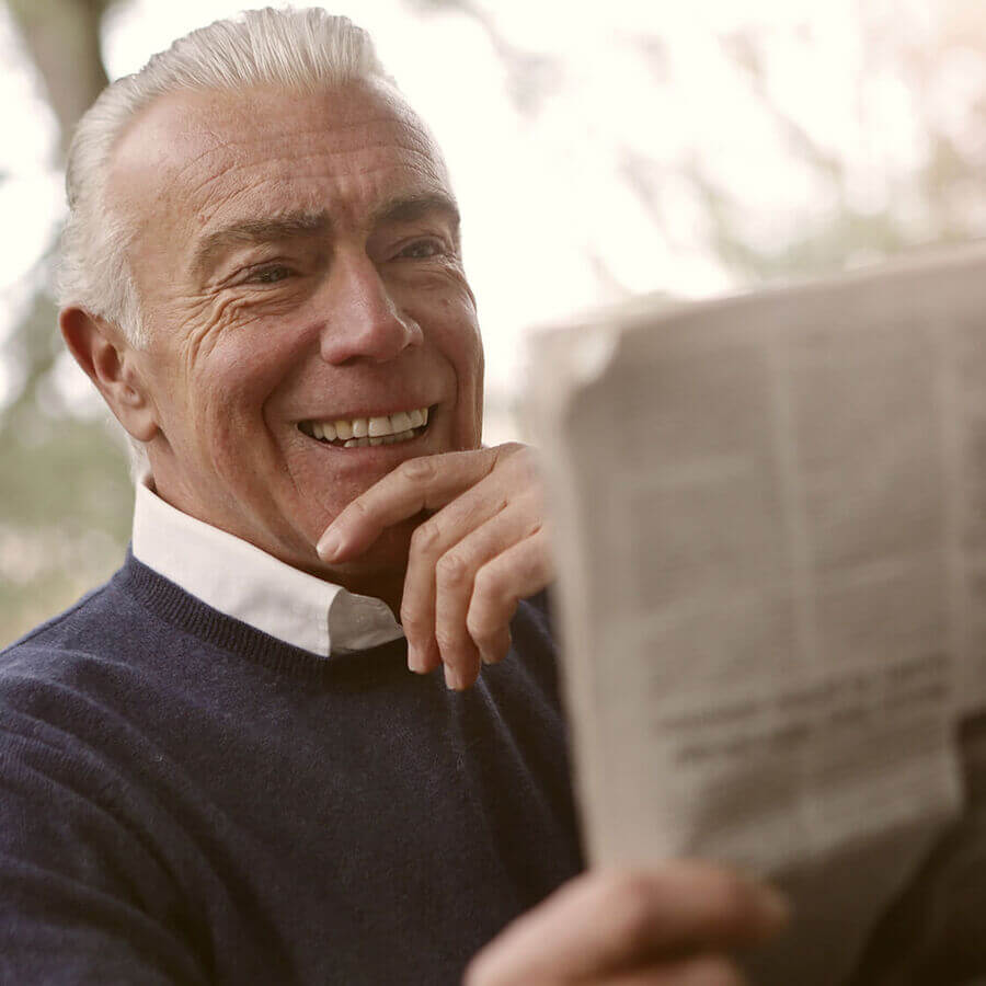 Idoso sorridente a ler o jornal