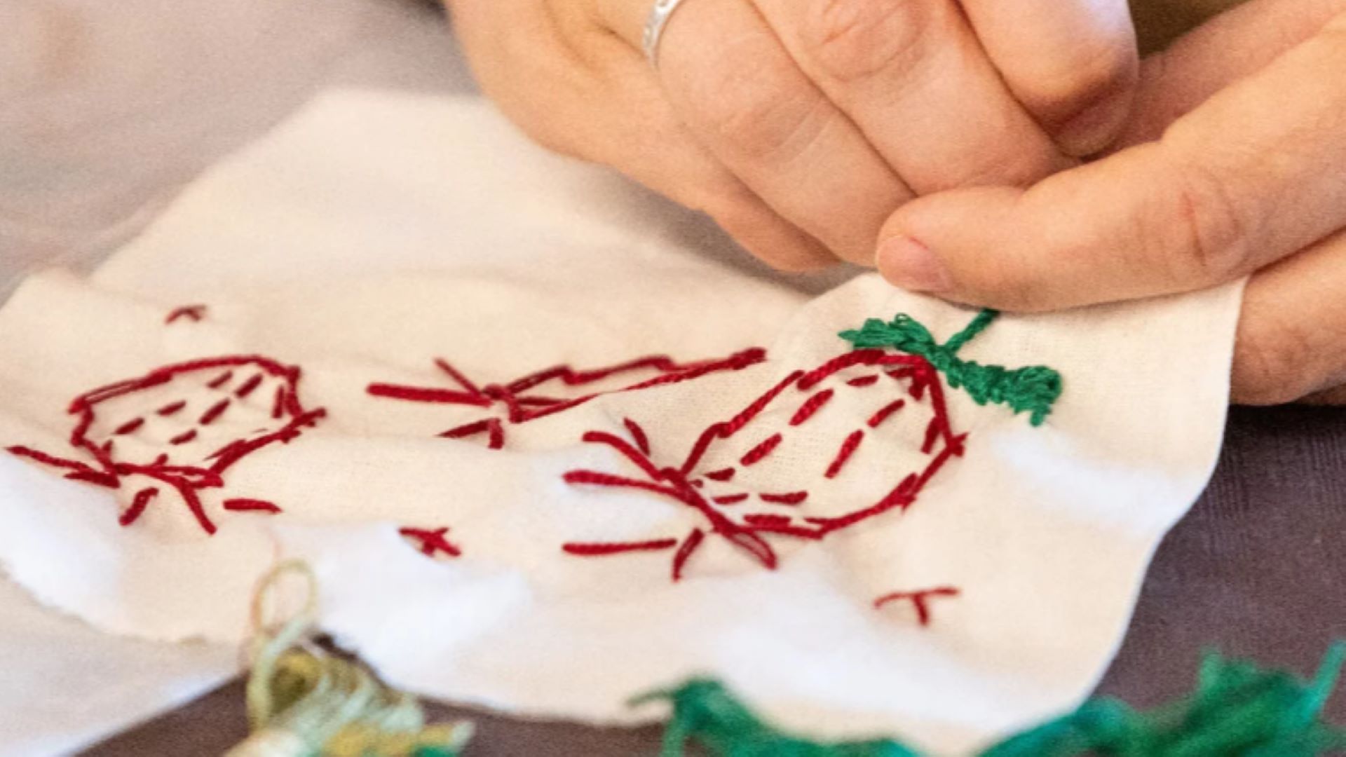 mãos a trabalharem em tapeçaria